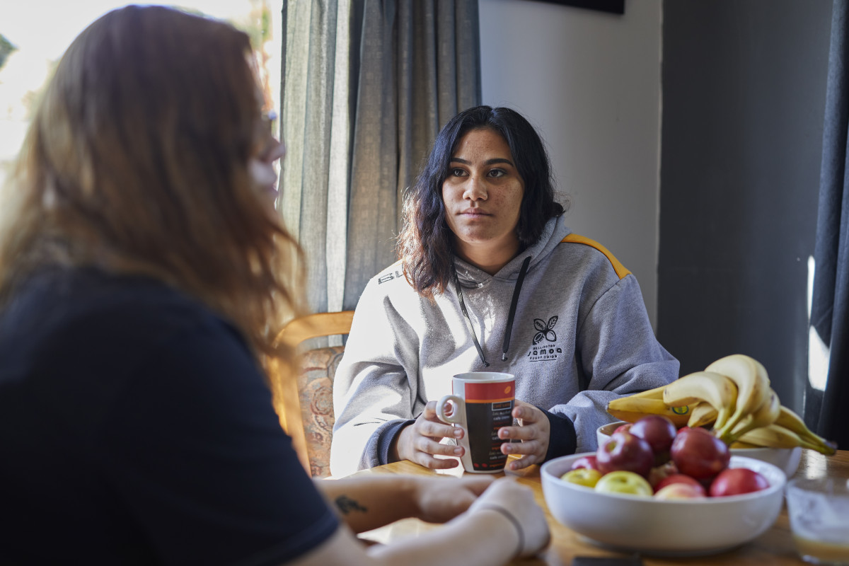 Two friends having a serious conversation over coffee, highlighting concern for family or friends' well-being