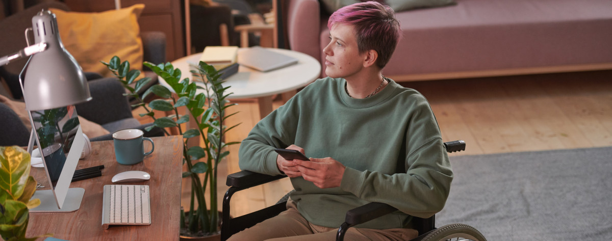 DISABLED info and support pink hair woman in wheelchair iStock 1296099163