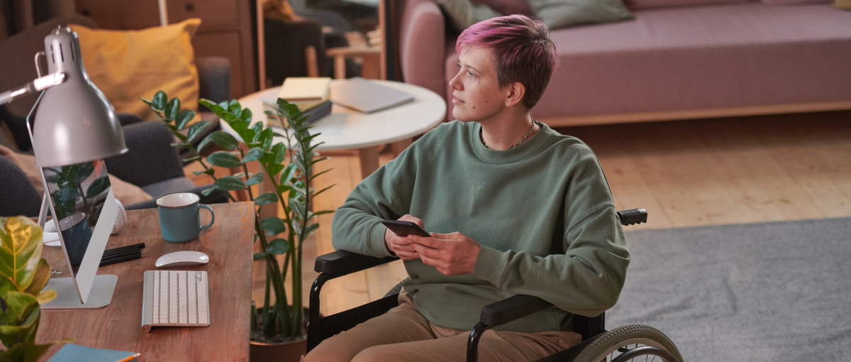 DISABLED info and support pink hair woman in wheelchair iStock 1296099163