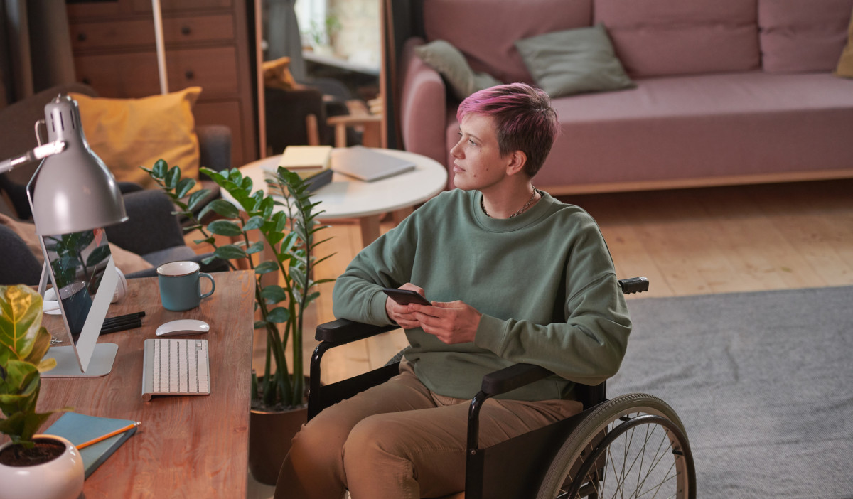 DISABLED info and support pink hair woman in wheelchair iStock 1296099163