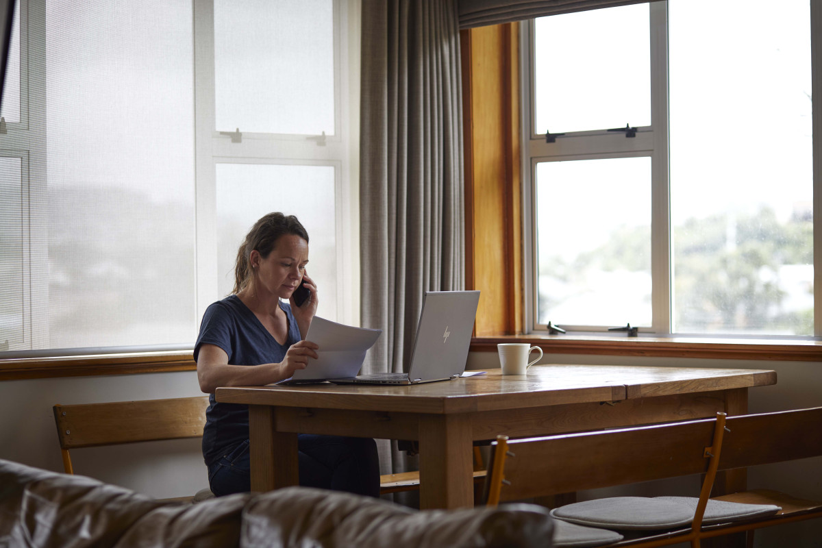 Woman working on laptop in a room, illustrating barriers to seeking safety from family violence