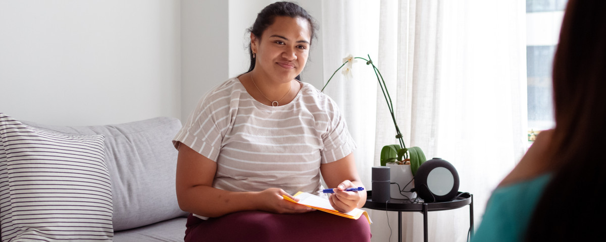 Social worker taking notes while providing support, representing the Service Finder for finding help services